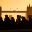 The silhouette of commuters walking past the Tower of London