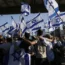 Protesters wave Israeli national flags in support of soldiers being questioned for detainee abuse, outside of the Sde Teiman military base
