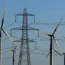A wind farm in front of a pylon