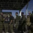 Israeli soldiers gather at the gate to the Sde Teiman military base