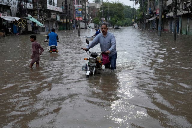 059bbbb3f0414824aee6e1a93f268fa2 Motorcyclists riding through a flooded road caused by heavy monsoon rainfall in Lahore, Pakistan