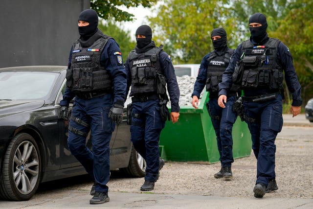 34cca591f6fb4be79f27e1811b445474 Gendarmes wearing balaclavas walk outside the residence of internet influencer Andrew Tate during an early morning police search raid on the outskirts of Bucharest, Romania