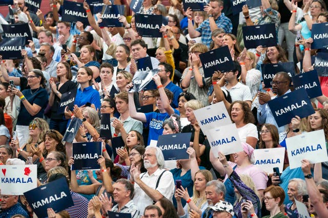 3e50d4c50573457587062a51f2a9919d A crowd of Kamala Harris supporters hold up placards in her name