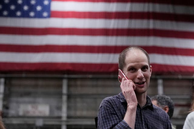 428ec7d753674054835a272ef7d585cd Evan Gershkovich on the phone with an American flag in the background