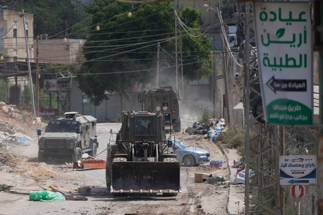 506269ca35c64a76ae2f756a75551e18 A bulldozer from the Israeli forces moves on a street during a military operation in the West Bank refugee camp of Al-Faraa