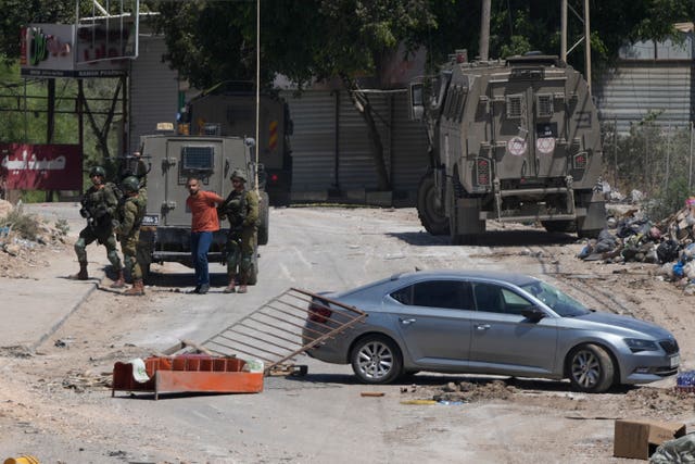 60f8d17c0af14219a5d04a3dd20bd3c6 A Palestinian man is detained by members of the Israeli forces