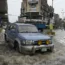 A vehicle drives through a flooded road caused by heavy monsoon rainfall in Lahore, Pakistan