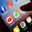 Person holding a smartphone with lots of apps