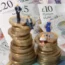 Some model people sat on a pile of UK coins and bank notes