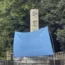 A blue sheet covers a stone pillar on which graffiti was found at Yasukuni Shrine in Tokyo (Kyodo News via AP)