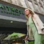 A woman walks past a Waitrose shop