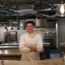 Chef Andy Beynon standing behind the worktop of the kitchen of Behind in Hackney, east London.