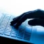 A hand on a laptop keyboard