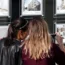 Two women look at property adverts in an estate agent's window