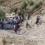 Volunteers recover bodies and injured passengers from the wreckage of a bus that fell into a ravine, near Kahuta, Pakistan
