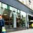 People walking past the glass windows of a branch of Waitrose