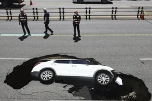 Driver and passenger injured as car is swallowed up by sinkhole