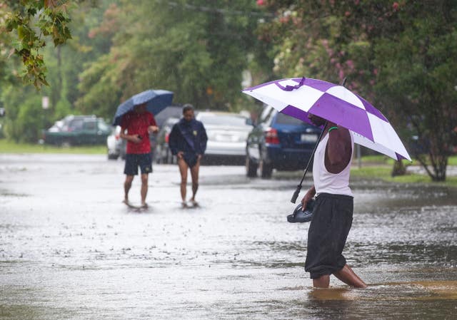 83ef2664412146df8d14fb324b192b2c People walk through flood waters at the intersection at Simons Street and Rutledge Avenue