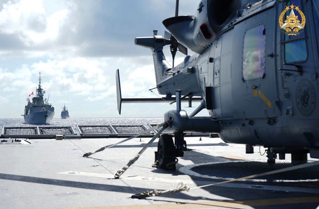 e0bfc13a2df4481fbf80fc05994ff440 A helicopter on the deck of an aircraft carrier